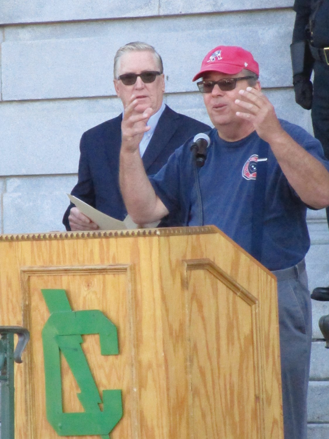 ‘SUPPORT YOUR COMMUNITY’:Cranston East social studies teacher Christopher Ogheltree addresses the crowd gathered for Saturday's ceremony as Mayor Ken Hopkins looks on.